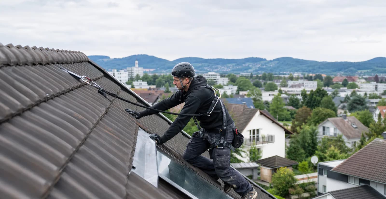 Dachdecker bei der fachgerechten Zustandsprüfung eines Ziegeldachs